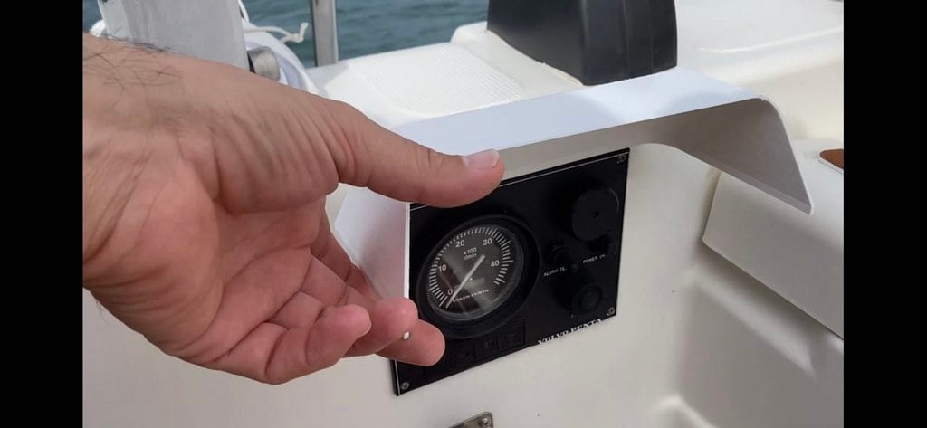 Gångjärnsförsett lock för panel på båtmotor