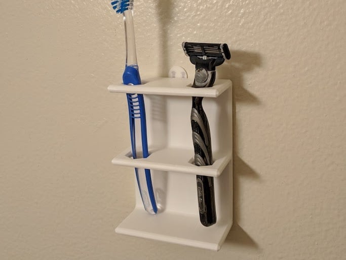 Väggmonterad hållare för tandborste eller rakapparat